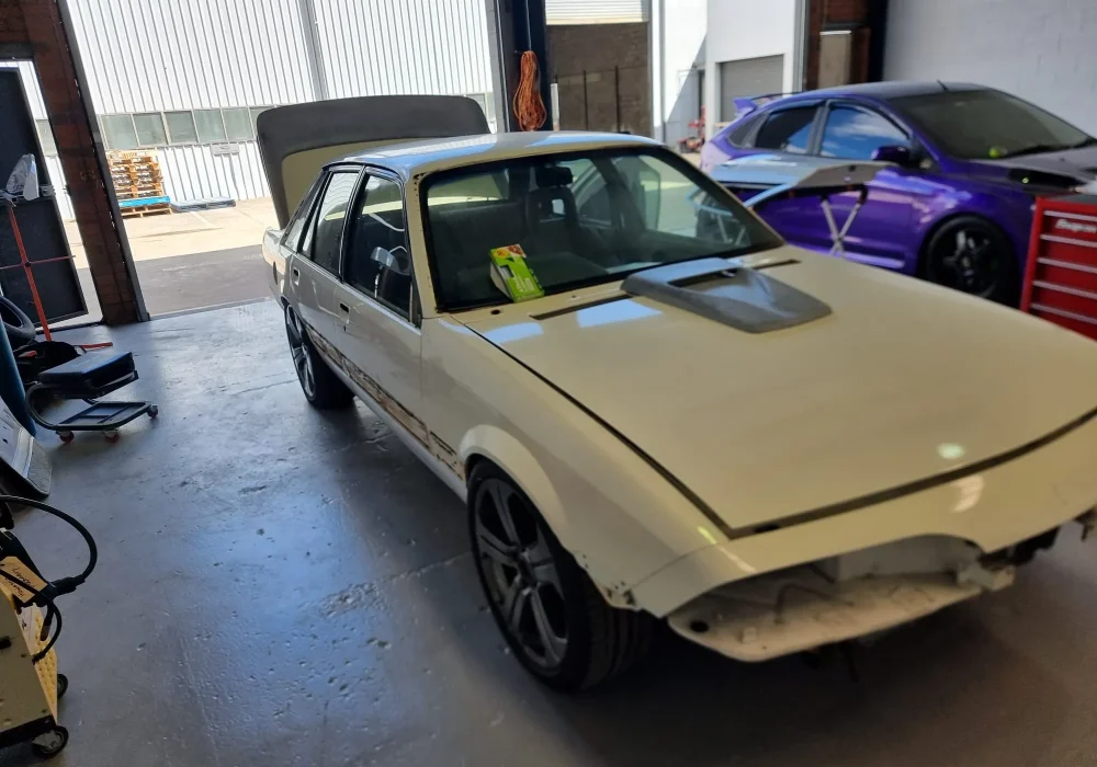 Insurance repair work in progress with vehicle masked for refinishing