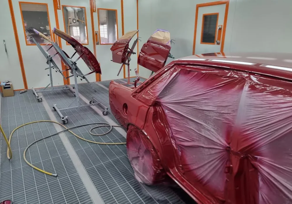 Automotive spray painting process inside controlled workshop environment
